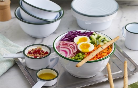 Ustensiles en acier émaillé contenant des crudités et un yaourt, accompagnés de sauce et de batonnets de pain à croquer