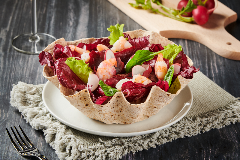 Salade de crevettes roses et batavia dans un bol comestible à base de farine de blé
